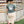 Load image into Gallery viewer, Person wearing a green t-shirt with a logo and text, standing in front of a wooden fence.
