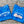 Load image into Gallery viewer, Two blue t-shirts with 'Wisconsin' text on a wooden surface