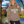 Load image into Gallery viewer, Person wearing a brown hoodie with 'WISCO UP' text, standing outdoors with trees and water in the background.