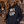 Load image into Gallery viewer, A woman wearing a navy blue hoodie with 'WI UP' printed on the front, a camouflage trucker hat with a 'WI UP' patch, and holding an olive green tumbler in an outdoor rustic setting.
