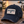 Load image into Gallery viewer, A distressed dark navy baseball cap with a white rectangular patch reading 'WISCONSIN UP' in navy and red, resting on a wooden table outdoors at sunset with a lake and dock in the background.
