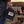 Load image into Gallery viewer, A person outdoors at sunset holds a navy baseball cap with a distressed patch reading “WISCONSIN UP.” The background shows a campfire scene in a field.

