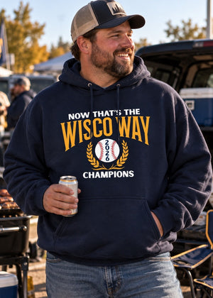A man wearing a navy blue hoodie with a 'Now That's The Wisco Way 2025 Champions' graphic, standing outdoors at a tailgate or barbecue event and holding a beer can.
