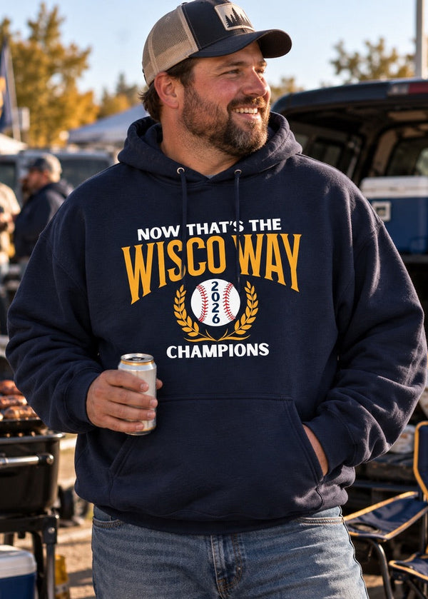 A man wearing a navy blue hoodie with a 'Now That's The Wisco Way 2025 Champions' graphic, standing outdoors at a tailgate or barbecue event and holding a beer can.