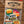 Load image into Gallery viewer, Wisconsin 'Wisco Livin' Pack' sticker set in a clear plastic bag with a kraft paper header card reading 'WISCONSIN UP Authentic Wisco Wear,' shown on a wood plank background with a red '$15' badge.
