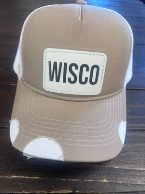 Tan trucker hat with WISCO leather patch, adjustable snapback, and breathable mesh back.