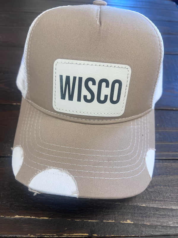 Tan trucker hat with WISCO leather patch, adjustable snapback, and breathable mesh back.