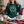 Load image into Gallery viewer, Person wearing a green hoodie with a smiley face design, sitting on a couch with a Christmas tree in the background.
