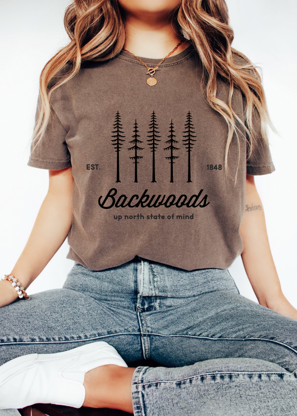 Person wearing a brown t-shirt with 'Backwoods' graphic design.