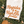 Load image into Gallery viewer, White t-shirt with &#39;Hayrides &amp; High Life&#39; text on grass with brown shoes
