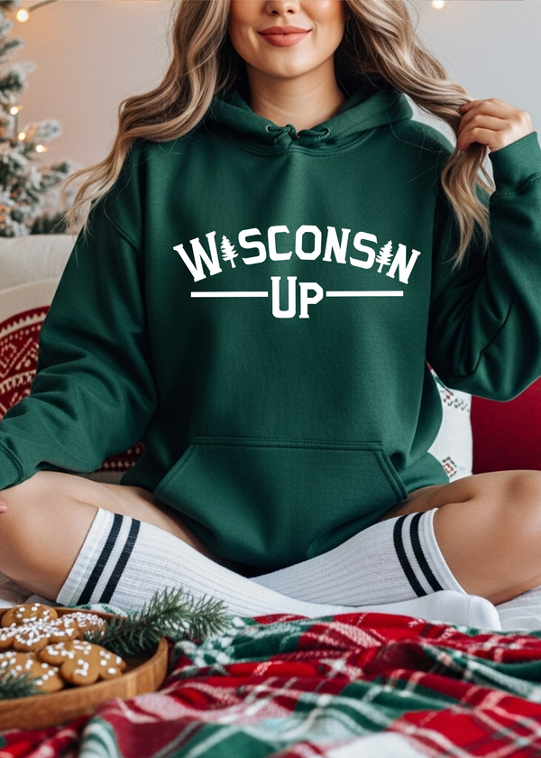 Person wearing a green hoodie with 'Wisconsin Up' text, sitting on a couch with Christmas decorations.