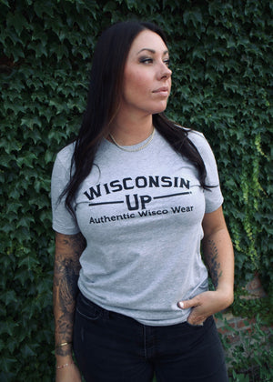 Woman wearing a 'Wisconsin Up' t-shirt against a green ivy background