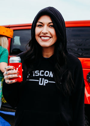 Woman wearing a black 'Wisconsin Up' sweatshirt holding a red cup with a Jeep in the background