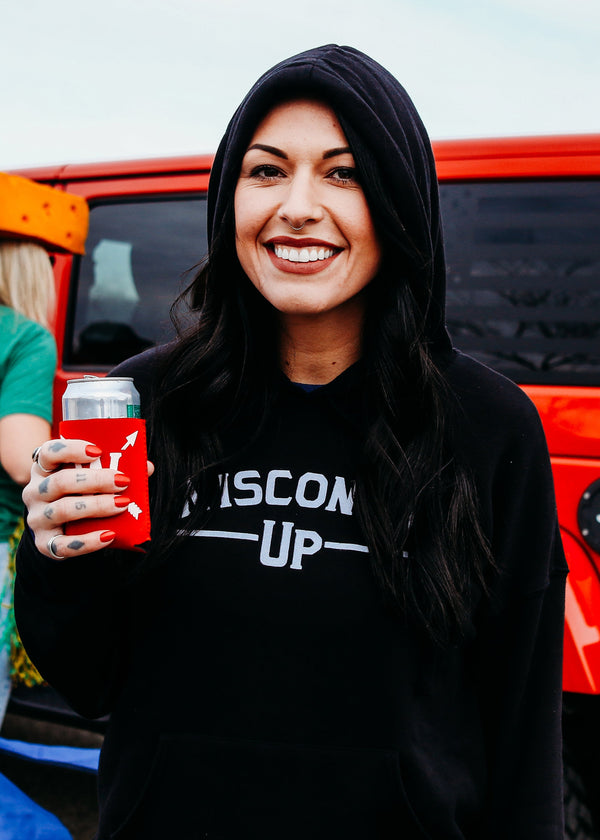 Woman wearing a black 'Wisconsin Up' sweatshirt holding a red cup with a Jeep in the background